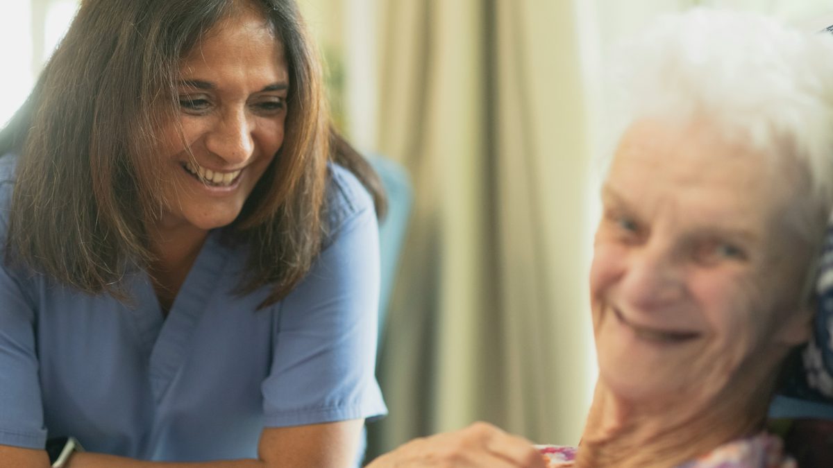 Nurse smiling with an older patient.
